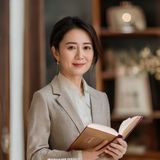 掌中美母母婴健康顾问张悦女士的专业形象照，她身穿浅色职业装，手持专业书籍，背景为温馨的咨询室，展现出母婴健康领域专业顾问的亲和与专业形象